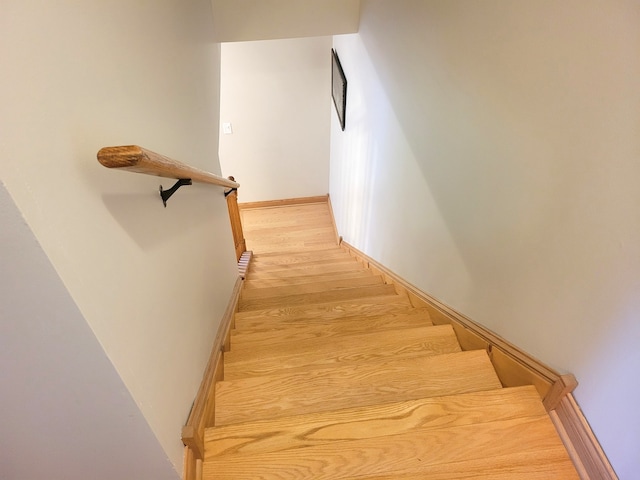 stairway with baseboards and wood finished floors