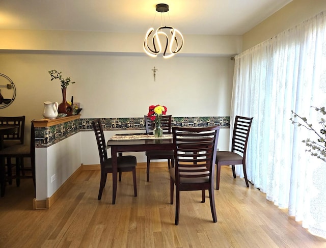 dining area with an inviting chandelier and light wood-type flooring