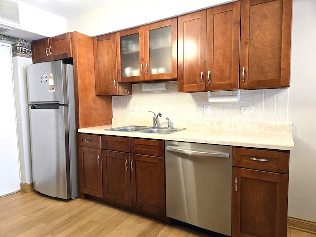 kitchen with visible vents, a sink, light countertops, light wood finished floors, and stainless steel appliances