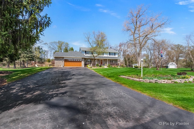 3518 James Way, Johnsburg, IL 60051 - traditional-style house with a front yard, an outbuilding, a storage shed, aphalt driveway, and an attached garage