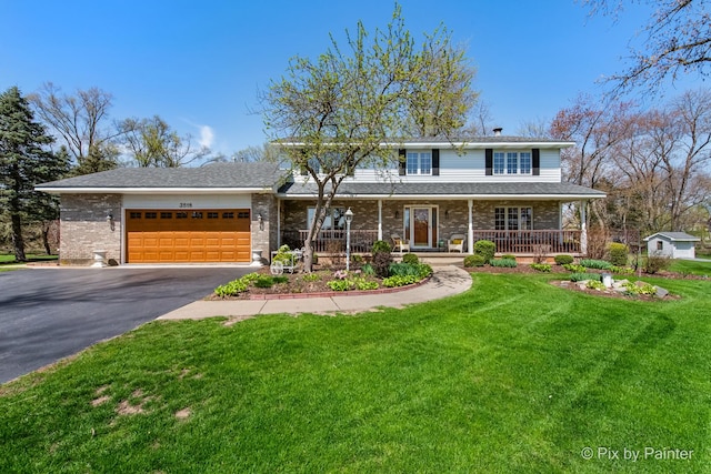 3518 James Way, Johnsburg, IL 60051 - view of front facade with a porch, a front lawn, driveway, brick siding, and an attached garage