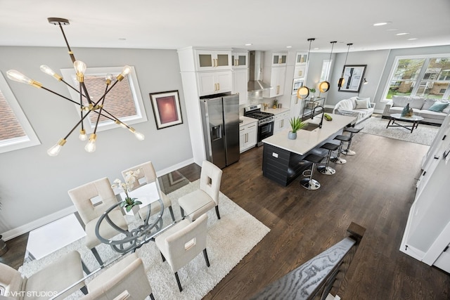living room featuring an inviting chandelier, dark wood finished floors, baseboards, and recessed lighting