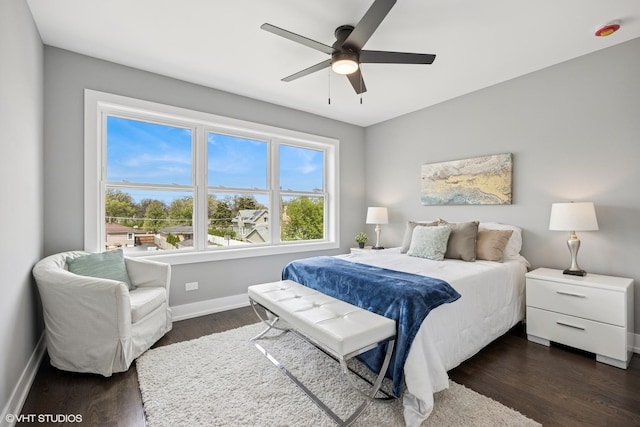 bedroom with baseboards, dark wood finished floors, and a ceiling fan