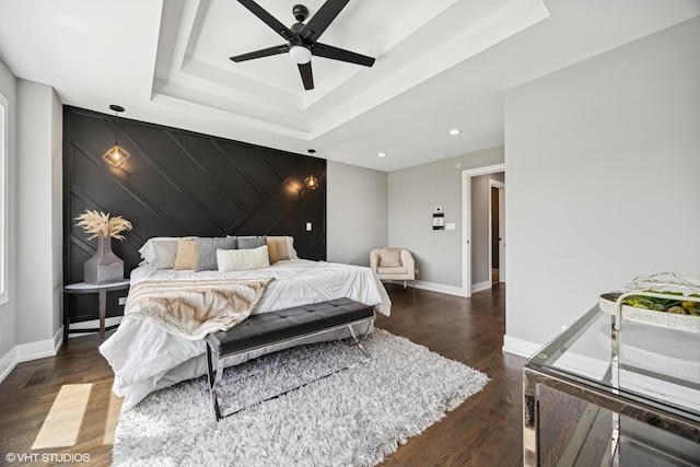 bedroom with wood finished floors, a ceiling fan, a tray ceiling, baseboards, and recessed lighting
