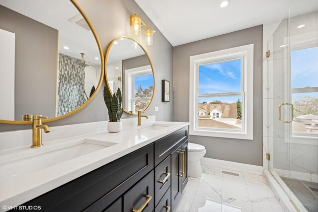 bathroom featuring plenty of natural light, a marble finish shower, marble finish floor, and a sink