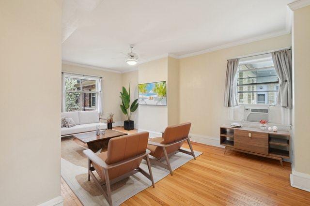 sitting room featuring crown molding, baseboards, ceiling fan, and light wood-type flooring