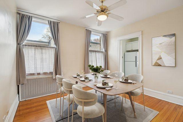 dining room featuring radiator heating unit, baseboards, a ceiling fan, and wood finished floors