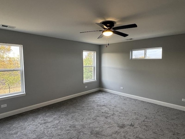 empty room featuring baseboards, visible vents, and a wealth of natural light