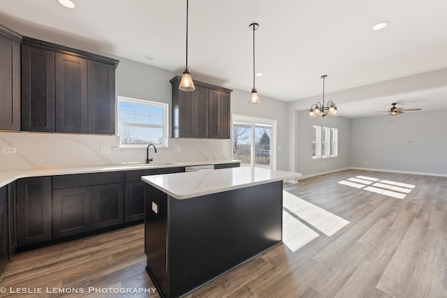 kitchen with hanging light fixtures, a sink, tasteful backsplash, and a healthy amount of sunlight