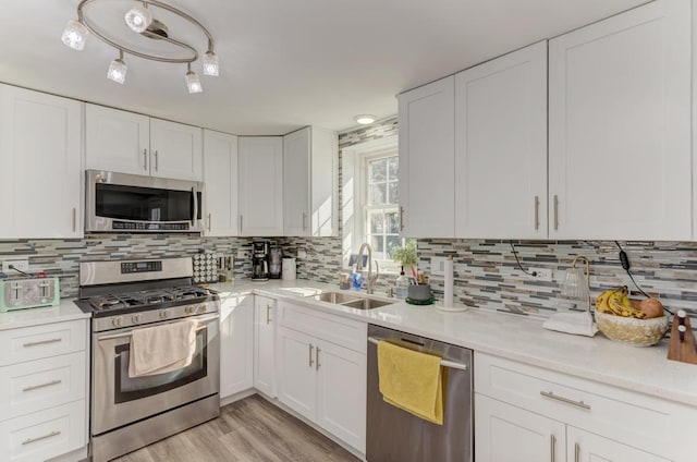 kitchen with appliances with stainless steel finishes, a sink, and light countertops