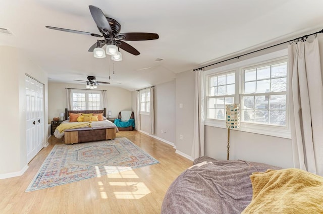 bedroom with light wood-type flooring, visible vents, a ceiling fan, and baseboards