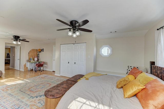 bedroom with baseboards, a ceiling fan, visible vents, and a closet
