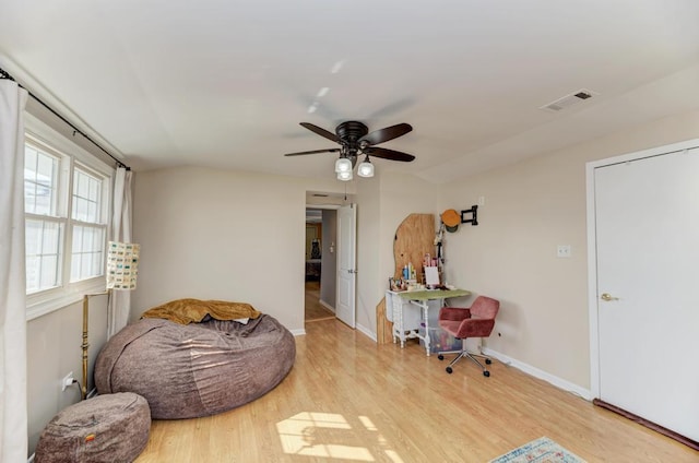 living area featuring ceiling fan, baseboards, light wood finished floors, and visible vents