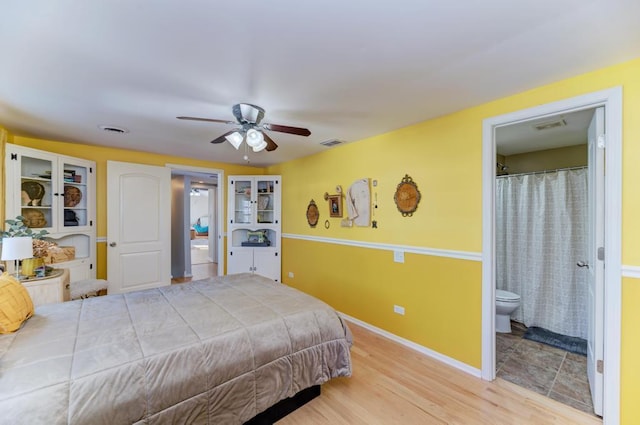 bedroom with connected bathroom, baseboards, and visible vents