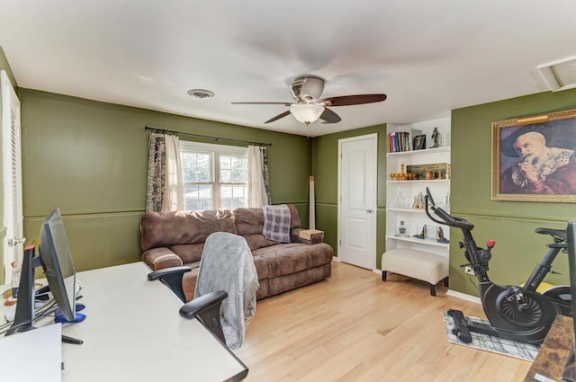 office featuring light wood finished floors, a ceiling fan, and visible vents