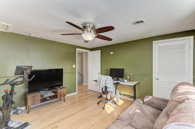 office featuring baseboards, wood finished floors, visible vents, and a ceiling fan