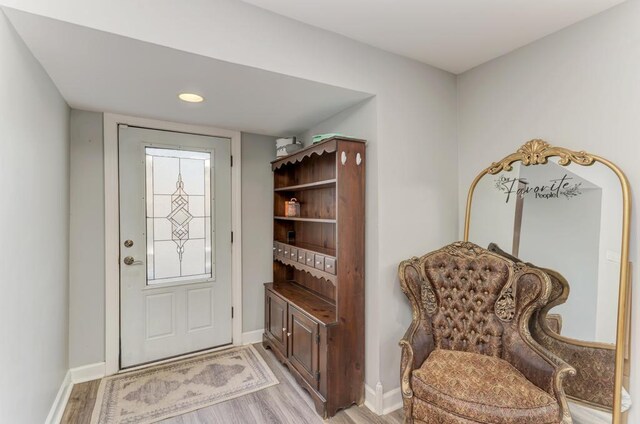 interior space featuring baseboards and light wood finished floors