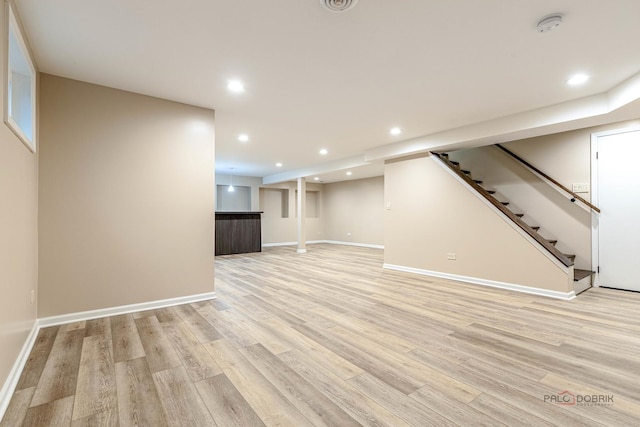 finished basement featuring stairway, baseboards, recessed lighting, and light wood finished floors