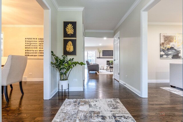 foyer entrance with baseboards, crown molding, dark wood-style floors, and visible vents