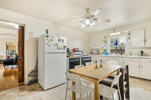 1127 Lathrop Ave, Forest Park, IL 60130 - kitchen with open shelves, white appliances, arched walkways, light countertops, and a ceiling fan
