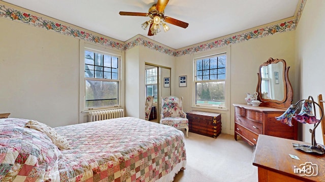 bedroom featuring radiator heating unit, a closet, light colored carpet, and multiple windows
