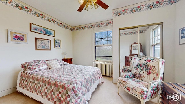 bedroom with radiator, a closet, ceiling fan, and carpet floors
