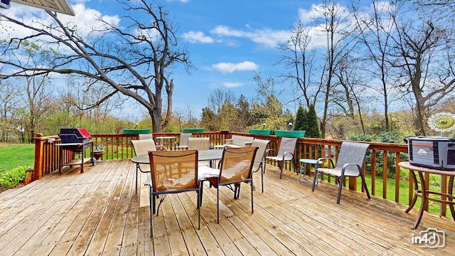 wooden terrace with outdoor dining area and grilling area