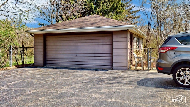 detached garage featuring fence