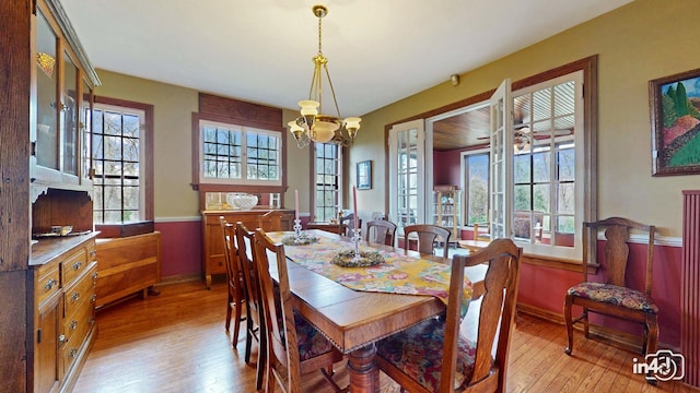 dining area with a chandelier, baseboards, and light wood-style floors