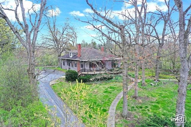 view of front of property featuring a chimney and driveway
