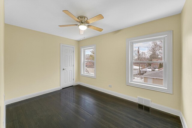 unfurnished room featuring visible vents, a ceiling fan, baseboards, and dark wood-style flooring