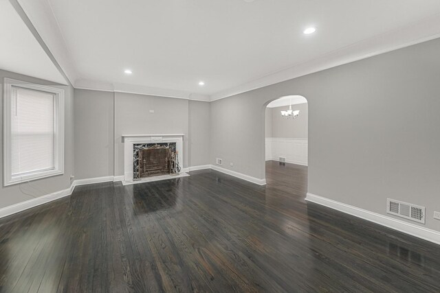 unfurnished living room with recessed lighting, wood finished floors, visible vents, arched walkways, and baseboards