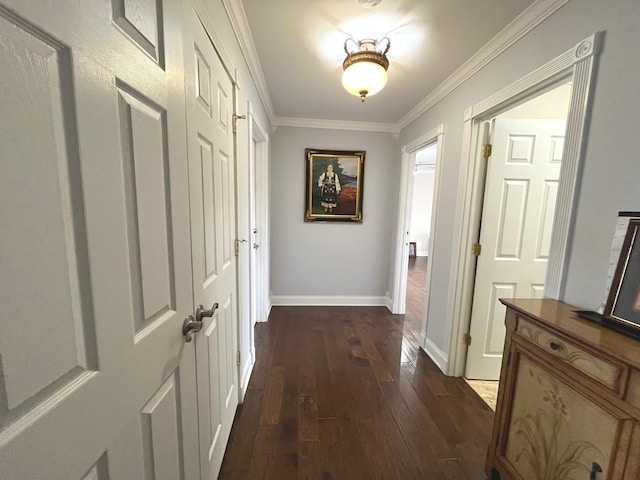 hallway featuring crown molding, baseboards, and dark wood finished floors