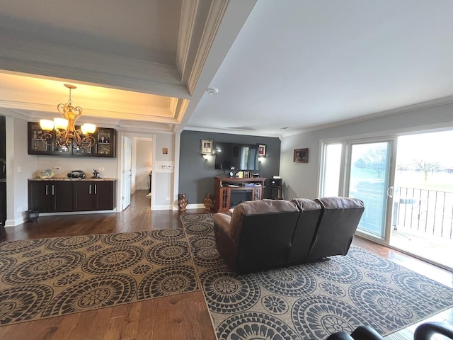 living room with a chandelier, baseboards, dark wood-style floors, and ornamental molding