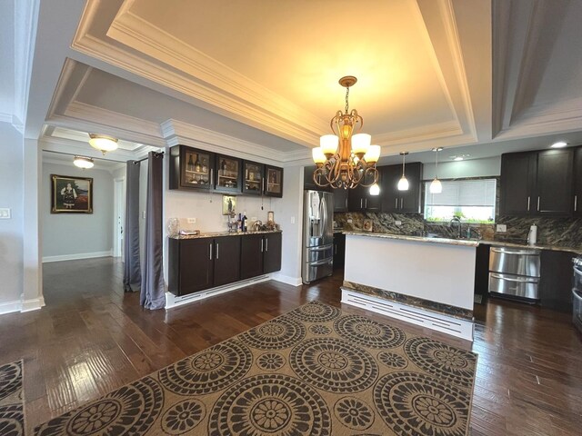 interior space with a notable chandelier, decorative backsplash, crown molding, and stainless steel appliances