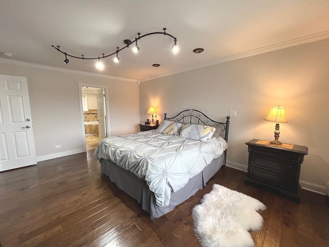 bedroom featuring wood finished floors, crown molding, baseboards, and connected bathroom