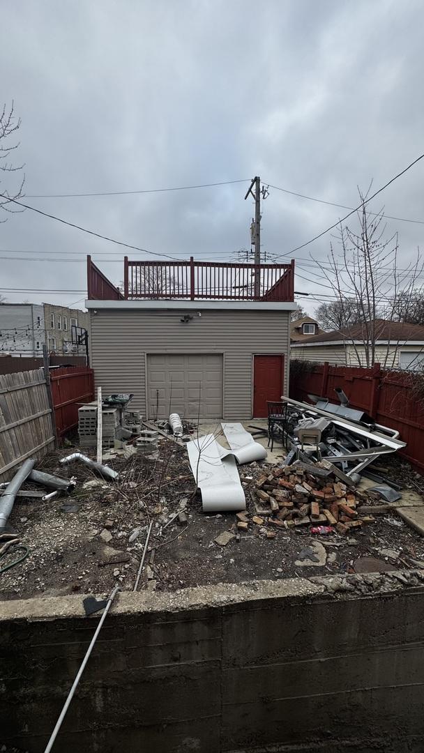 exterior space with fence, a balcony, and a garage