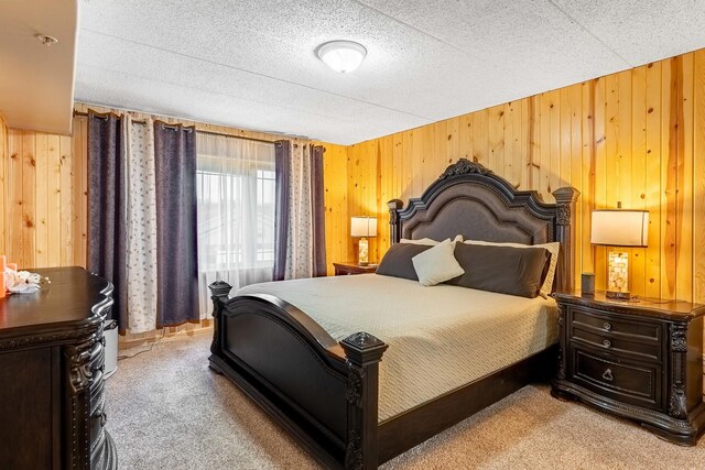 bedroom with wooden walls and carpet floors
