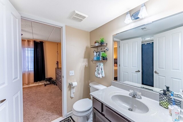 full bathroom with toilet, a shower with curtain, vanity, and visible vents
