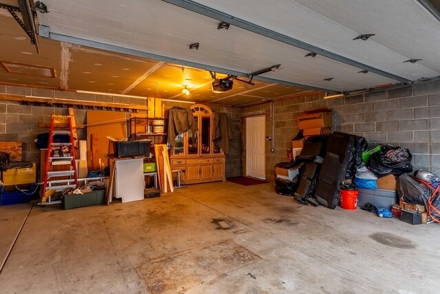 garage with concrete block wall and a garage door opener