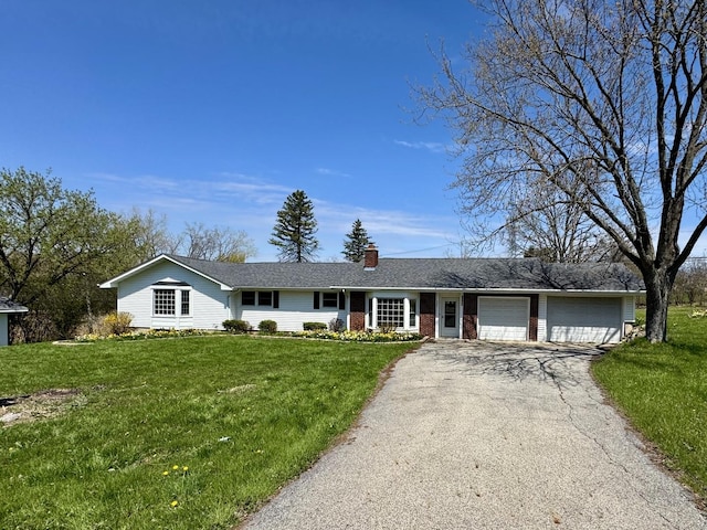 ranch-style house featuring a front lawn, aphalt driveway, a chimney, brick siding, and an attached garage