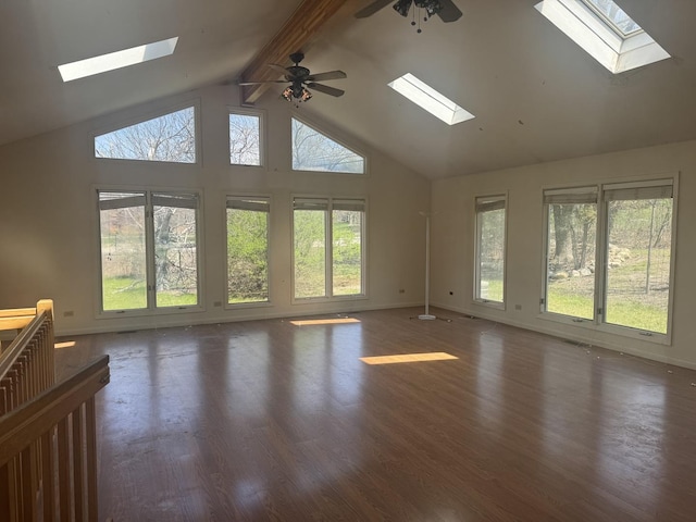 unfurnished living room with a skylight, a healthy amount of sunlight, and high vaulted ceiling