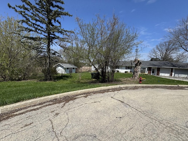 view of front facade featuring driveway, a front lawn, and a garage