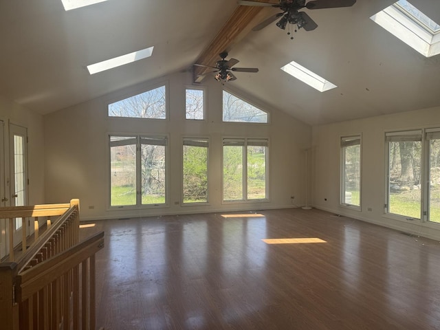 unfurnished living room with ceiling fan, a wealth of natural light, and a skylight
