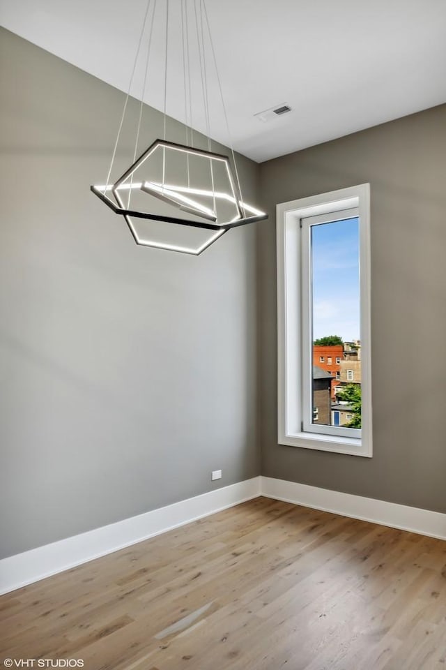 4816 S St Lawrence Ave Unit 302, Chicago, IL 60615 - unfurnished room with a chandelier, baseboards, and light wood-style flooring