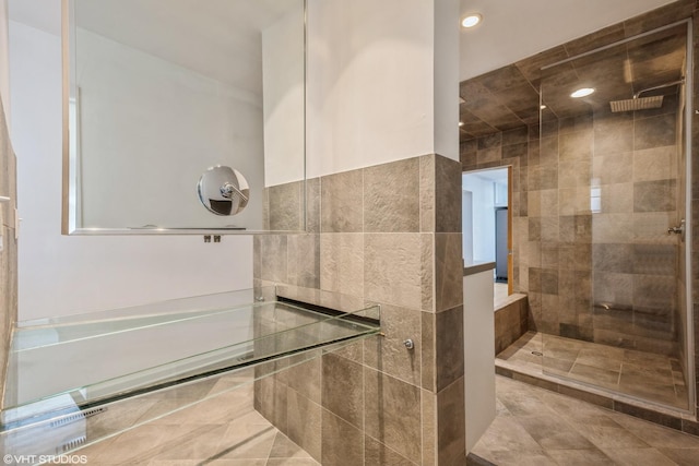 bathroom featuring recessed lighting, tile walls, and a stall shower
