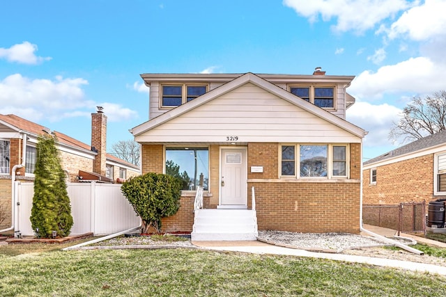 bungalow-style home with brick siding, central air condition unit, a front yard, and fence