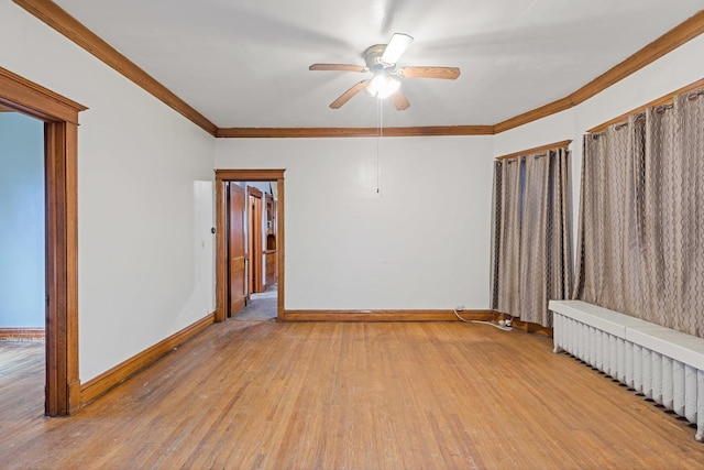 empty room featuring ceiling fan, baseboards, radiator, ornamental molding, and light wood finished floors