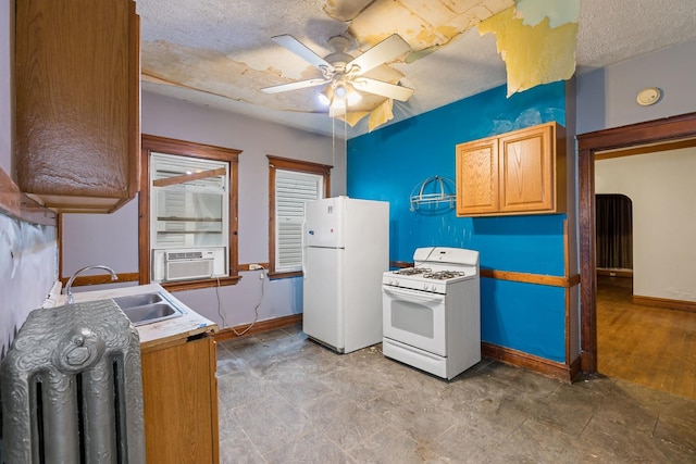 kitchen with a sink, white appliances, cooling unit, a ceiling fan, and baseboards
