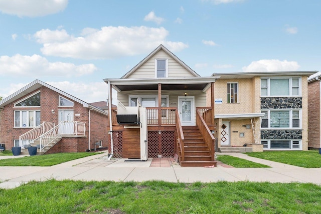 view of front of home featuring stairway, a front lawn, and covered porch